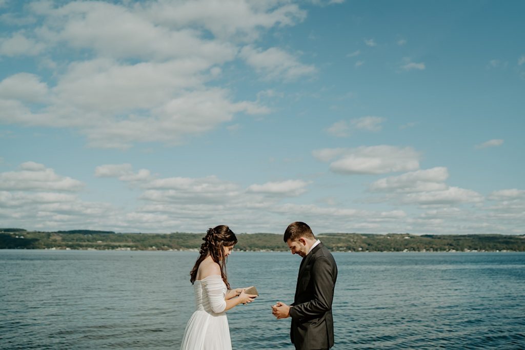 Bride and groom exchange vows in front of water on the Finger Lakes during intimate elopement