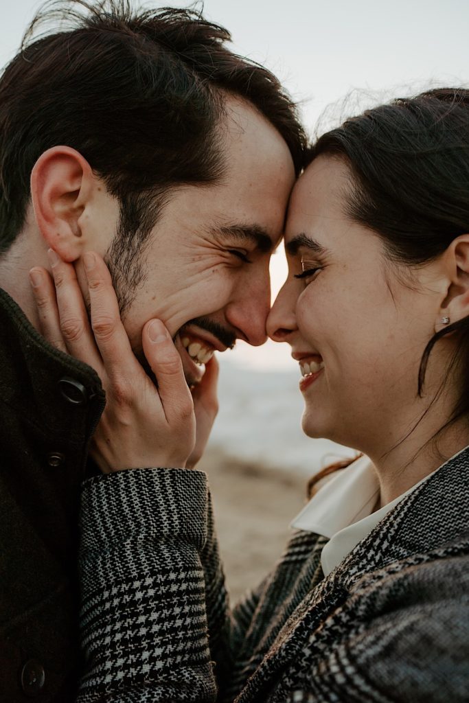 Closeup photo of couple smiling and putting their foreheads and noses together