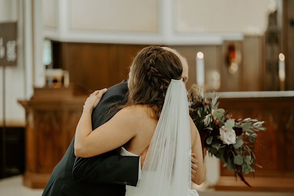 Bride and father bug after he walks her down the aisle for her wedding ceremony