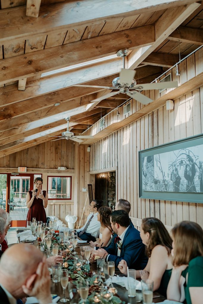 Bridesmaid gives a toast to bride and groom during intimate wedding reception
