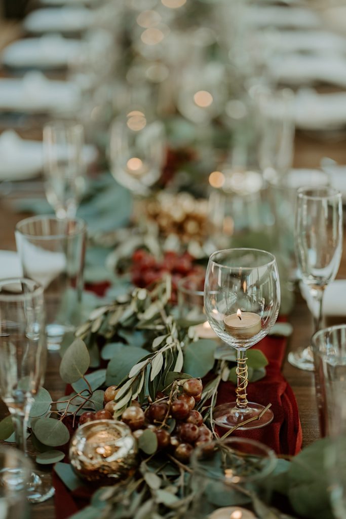 A table decorated with flowers, candles, glasses and plates for a wedding reception