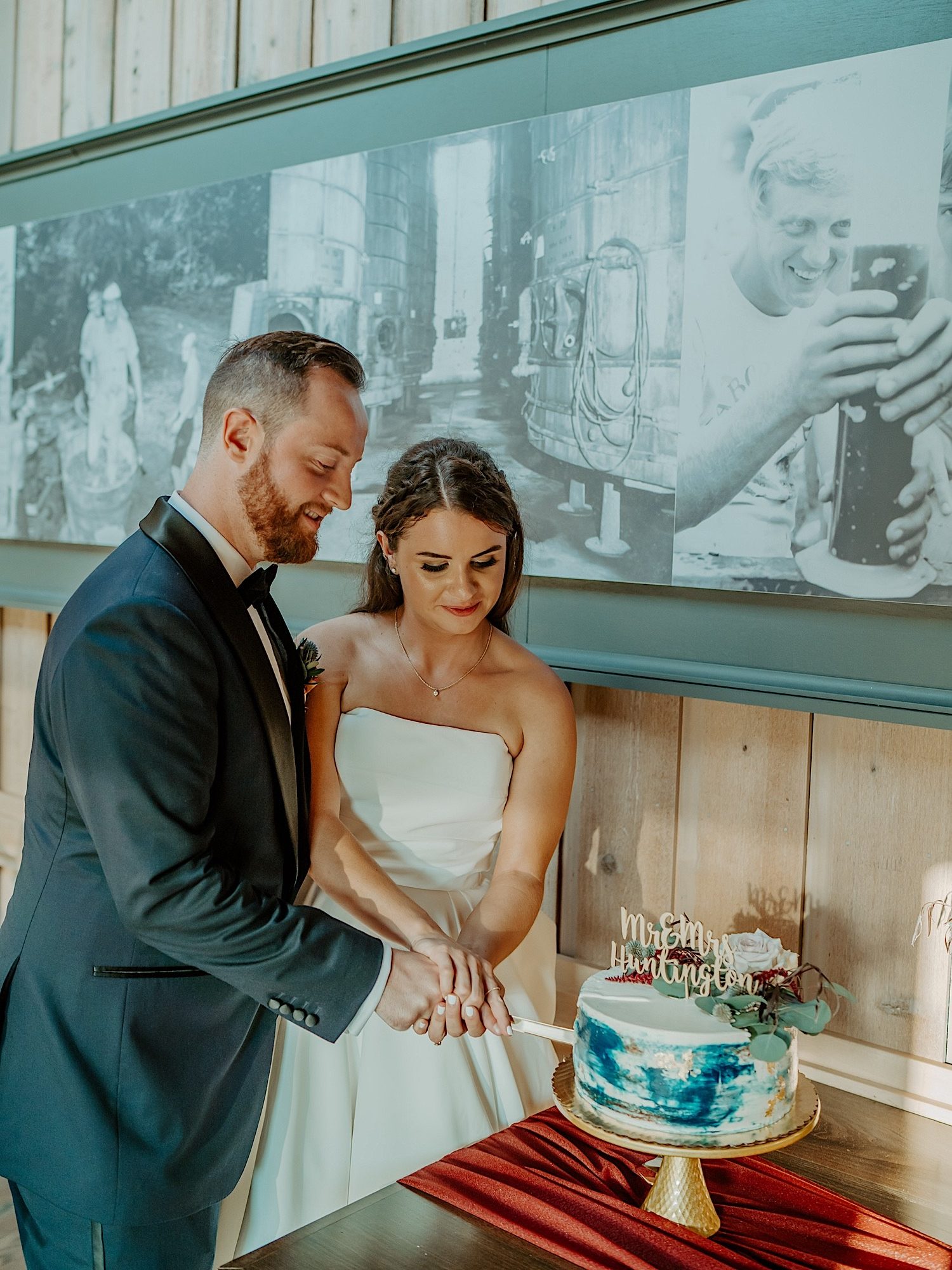 Bride and groom cut the first piece of their wedding cake together
