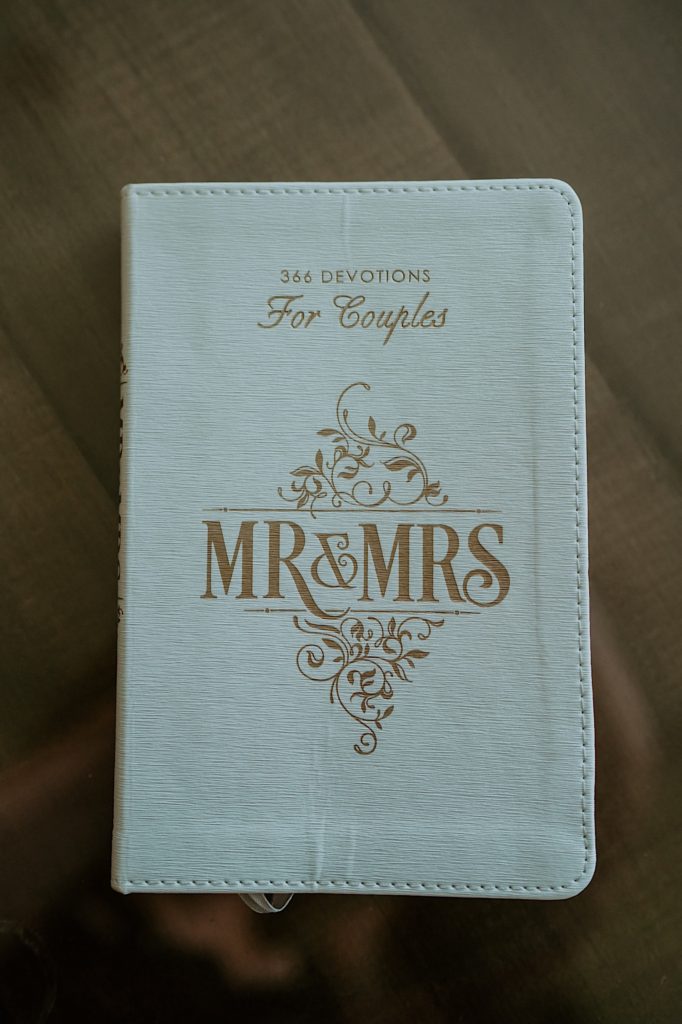 Close up photo of a white book with the writing "366 Devotions For Couples, MR&MRS" on it