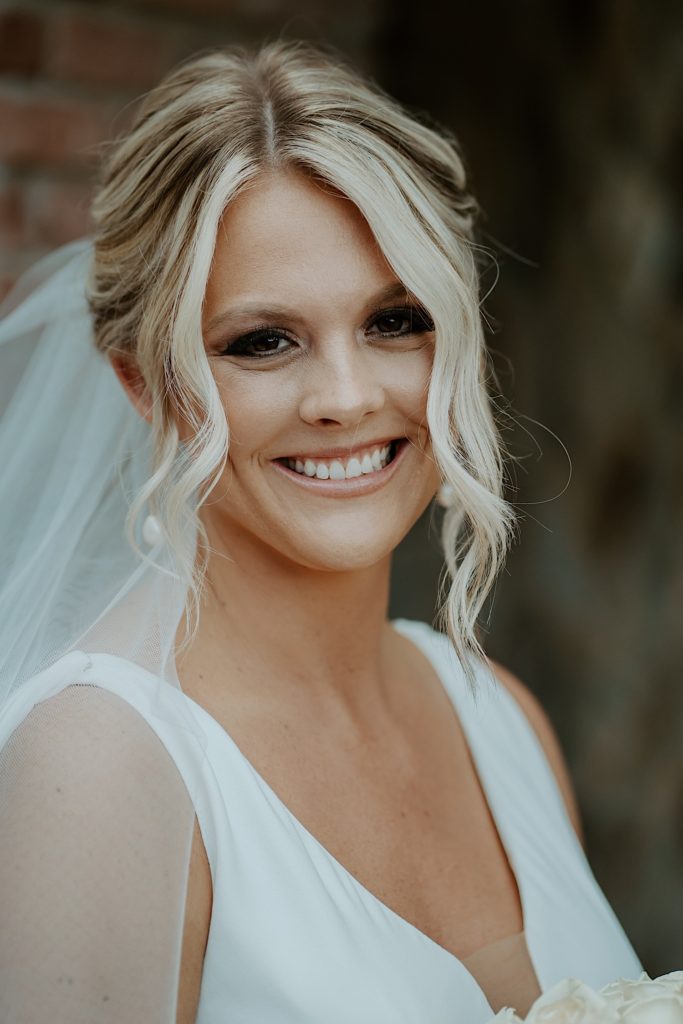 Portrait of a bride smiling at the camera wearing her wedding dress