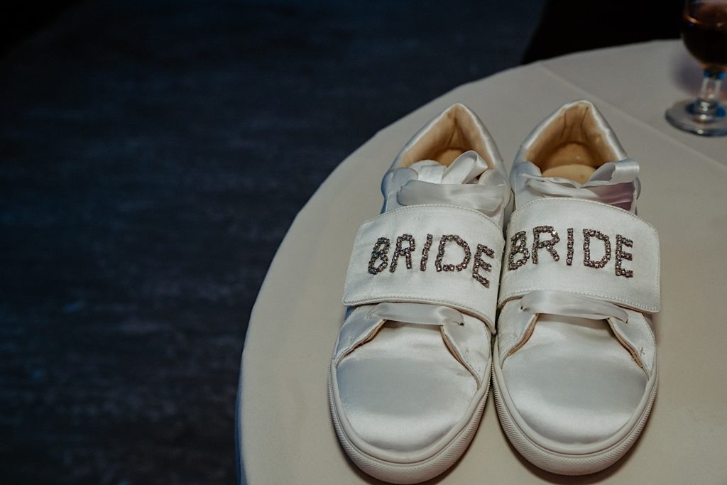 Photo of comfortable shoes on a table that have the word "Bride" on each shoe