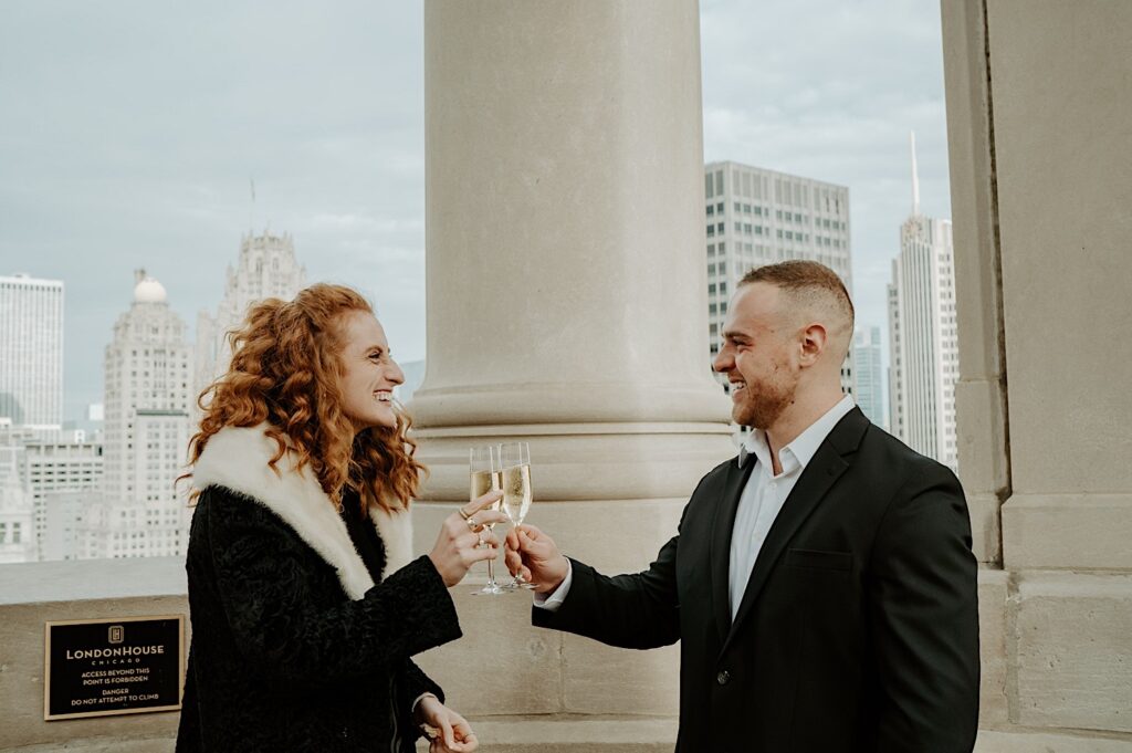 Fiancés cheers champagne after their proposal at the LondonHouse Cupola