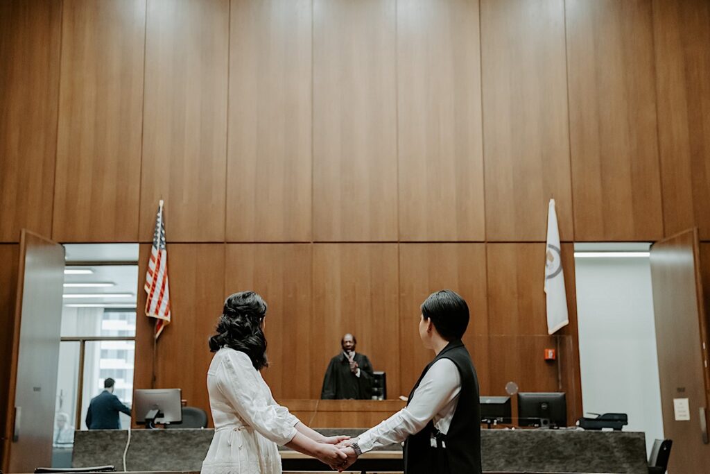 Two wives stand in front of a judge during their wedding ceremony at Chicago City Hall