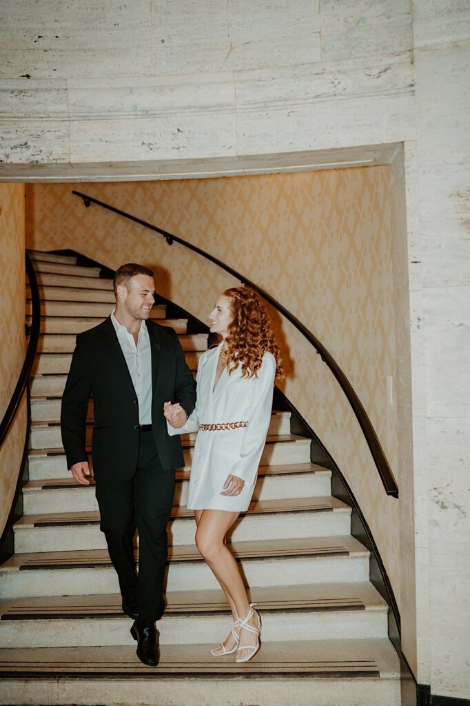 A couple walks down the steps of the Palmer House in Chicago prior to their elopement