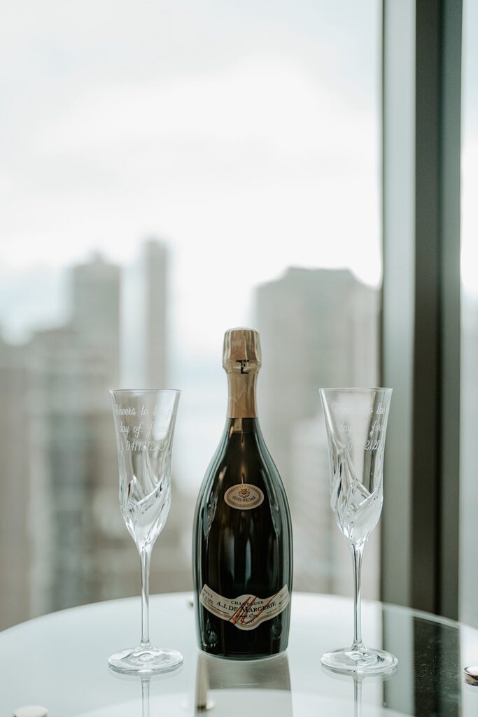 Champagne with custom champagne flutes on a glass table in a Chicago skyscraper.