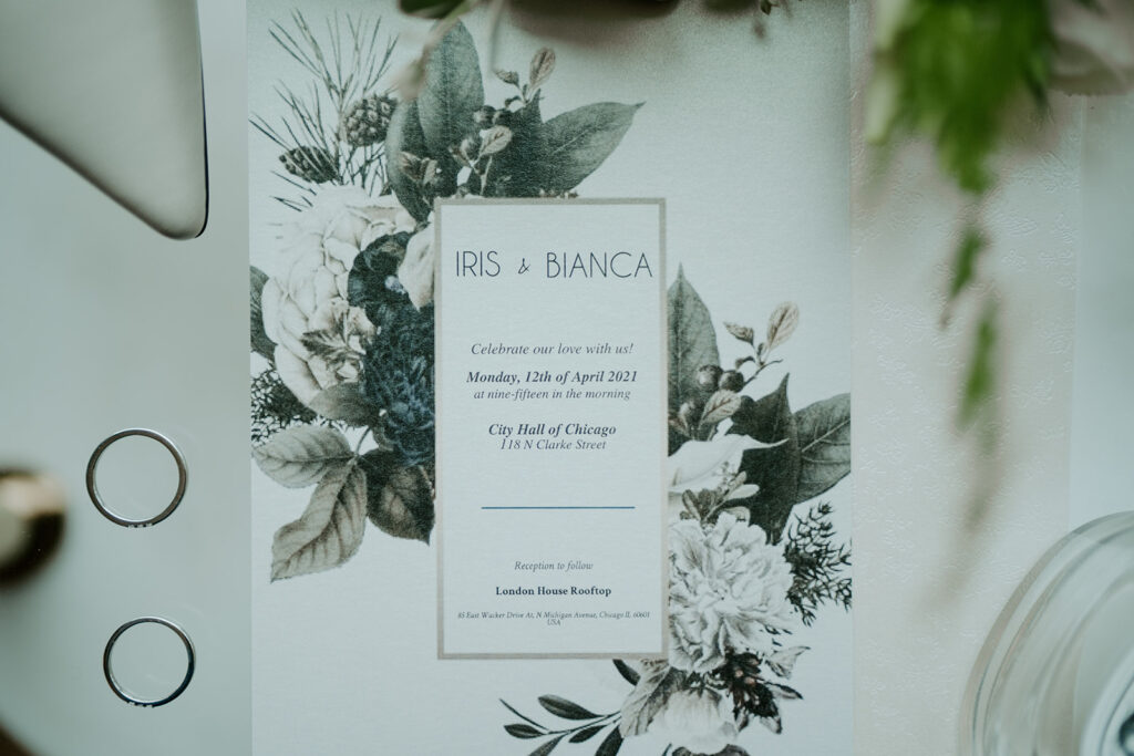 A wedding day flat lay with a mint green and white invitation for the LGBTQ couples elopement at City Hall in Chicago
