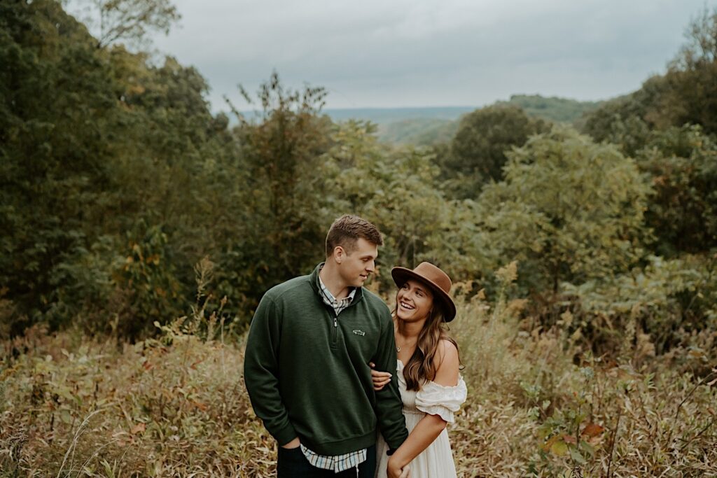 Fiancé's hold hands and smile at each other during their engagement session at Brown County State Park in Indiana.  