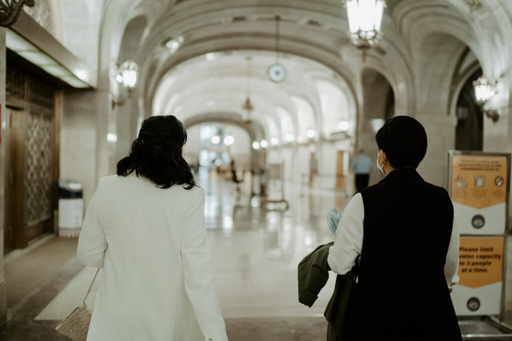 An engaged couple walks through Chicago's city hall with their masks on to get married at the Cook County Courthouse.