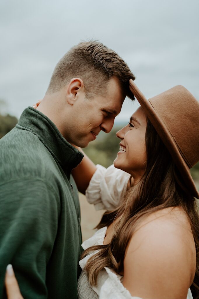 Fiancé's hug each other tight while smiling at one another during their engagement session at Brown County State Park in Indiana.  