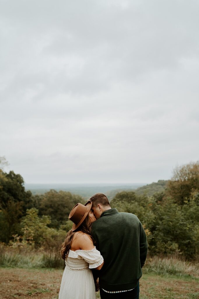 Fiancé's hold each other tight while smiling and looking at one another walking through Brown County State Park.