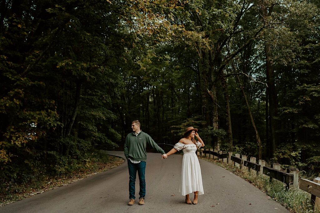 Fiancé's hold hands and look away from each other at Brown County State Park during their Indiana engagement session