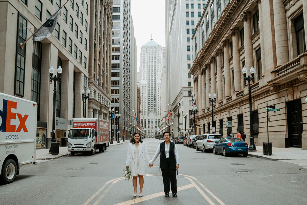Newly weds stand in front of the Chicago board of trade building in Chicago for their wedding portraits.