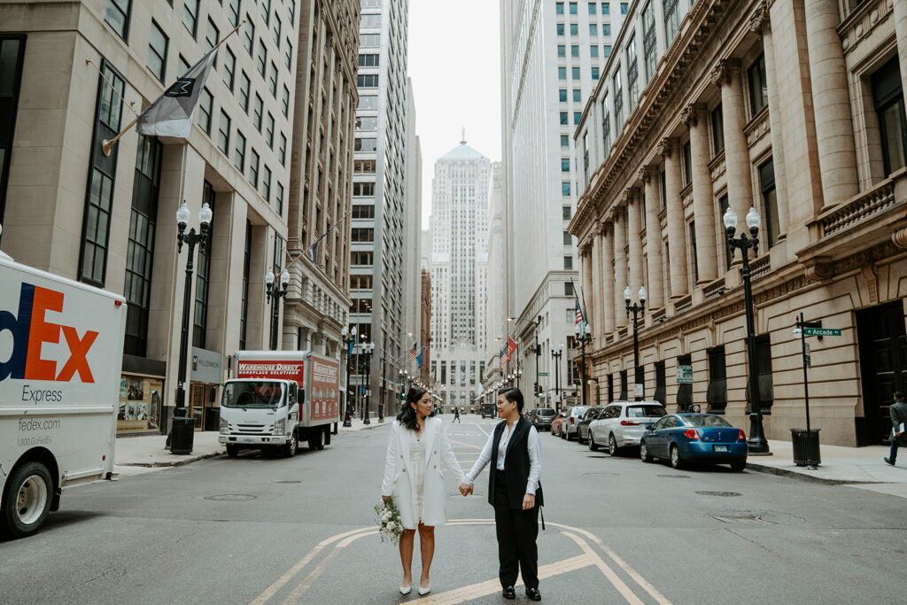 Newly weds stand in front of the Chicago board of trade building in Chicago for their wedding portraits.
