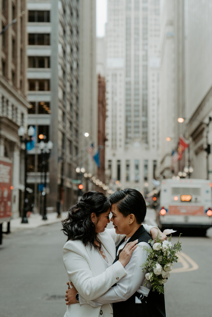 Newly weds stand in the middle of a street in Chicago sharing an intimate moment with one another.