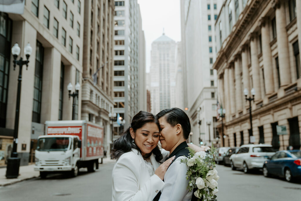 Newly weds stand in the middle of a street in Chicago sharing an intimate moment with one another in downtown Chicago after their elopement.