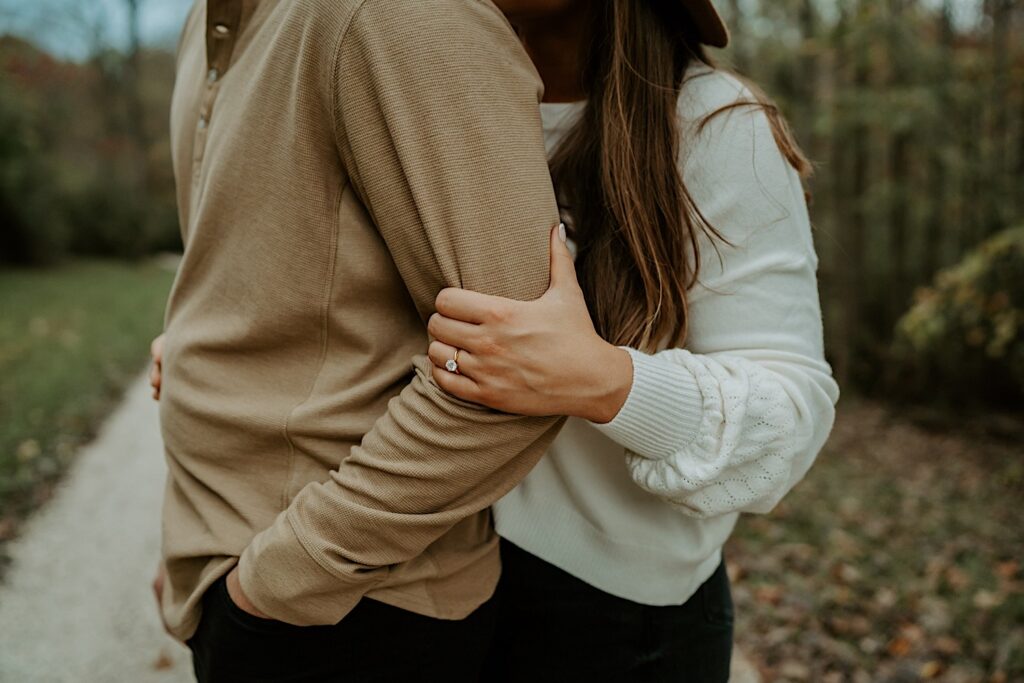 Fiancées hold each other tight and the camera zooms in close to the engagement ring.