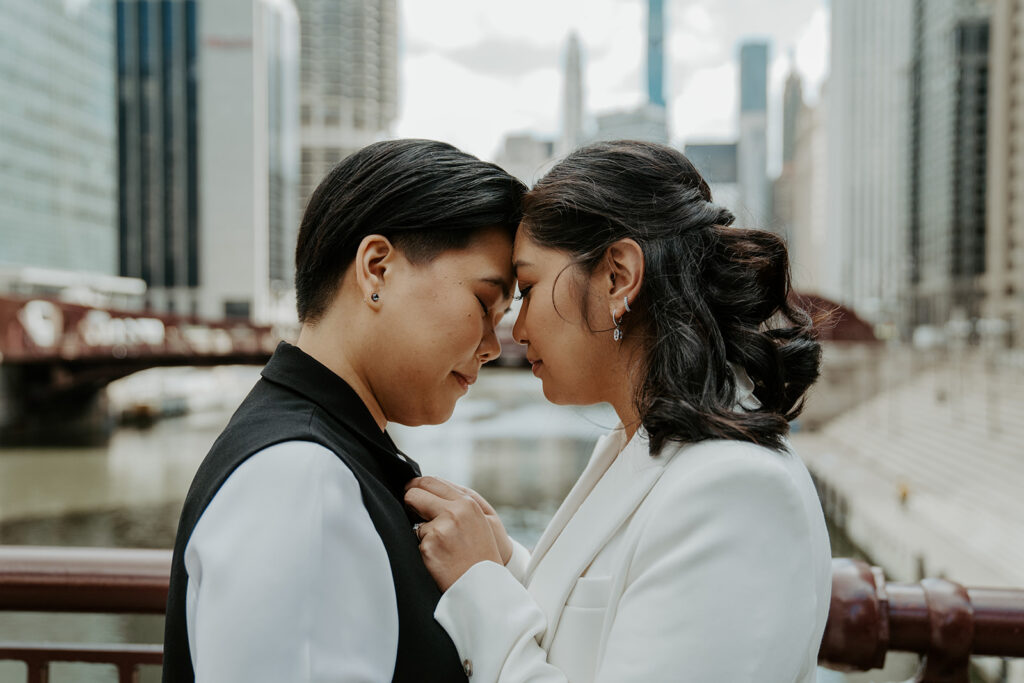 Two brides stand on Dusable bridge during their wedding portraits in the city of Chicago