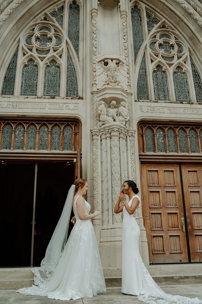 Brides stand and talk with each other in front of Scottish Rite Cathedral before their wedding ceremony.