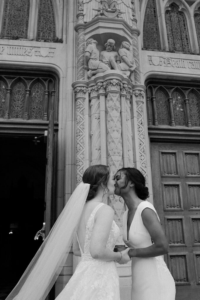 Brides kiss in front of Brides in front of Scottish Rite Cathedral before their wedding ceremony in Indianapolis. 