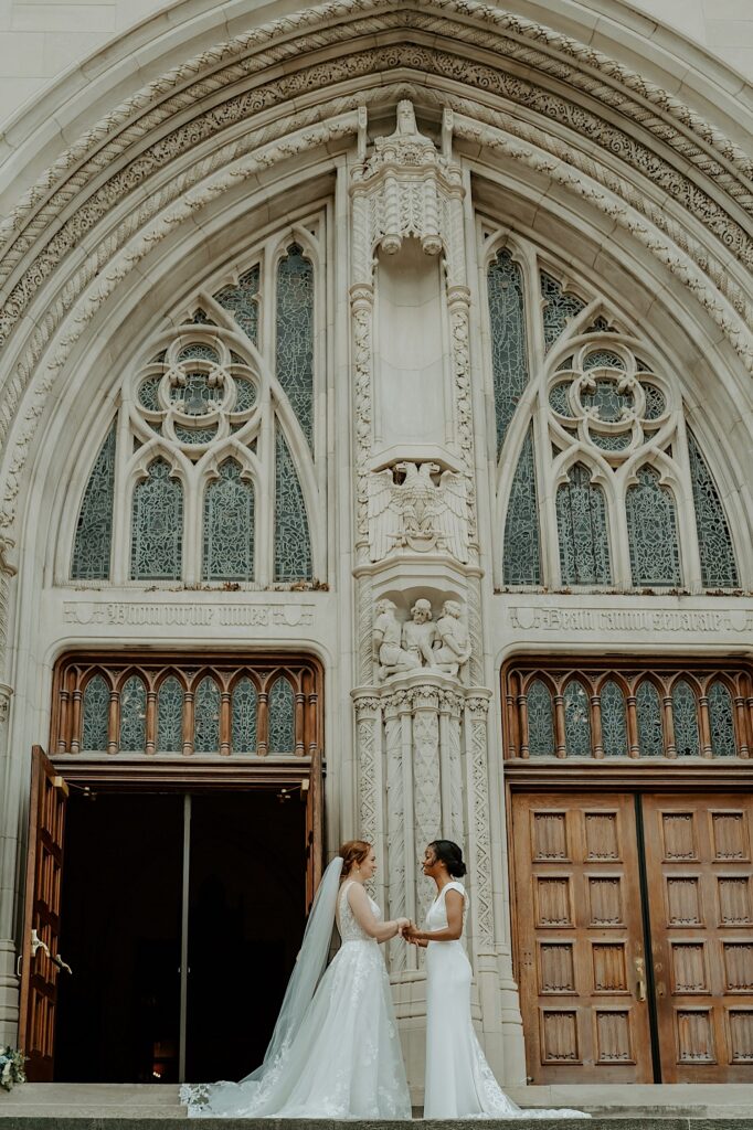 Brides hold hands and talk with each other before their LGBTQ ceremony in Indianapolis.