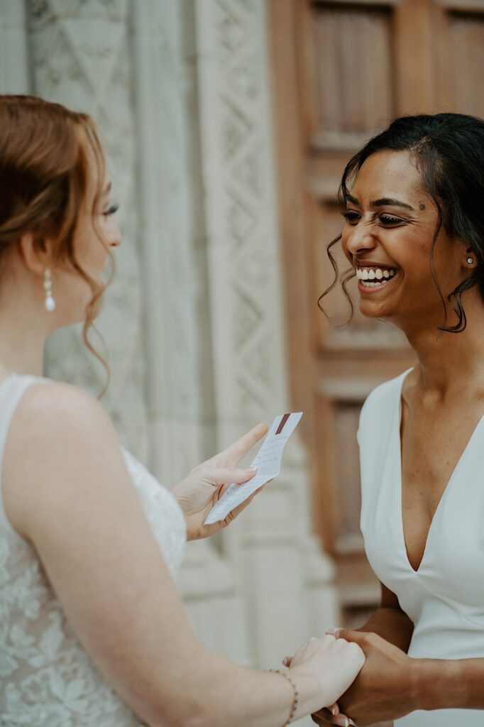 Bride reads a note to her soon to be wife as she laughs before their wedding ceremony at Scottish Rite Cathedral. 