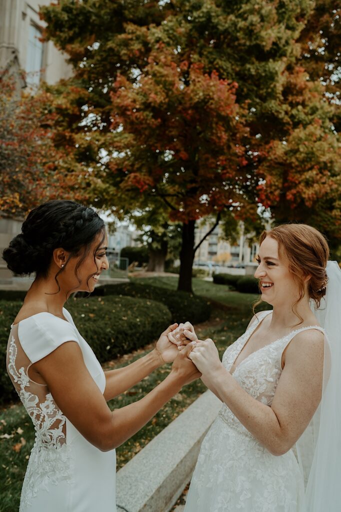 Brides look at each other while holding hands in downtown Indianapolis before their wedding ceremony. 