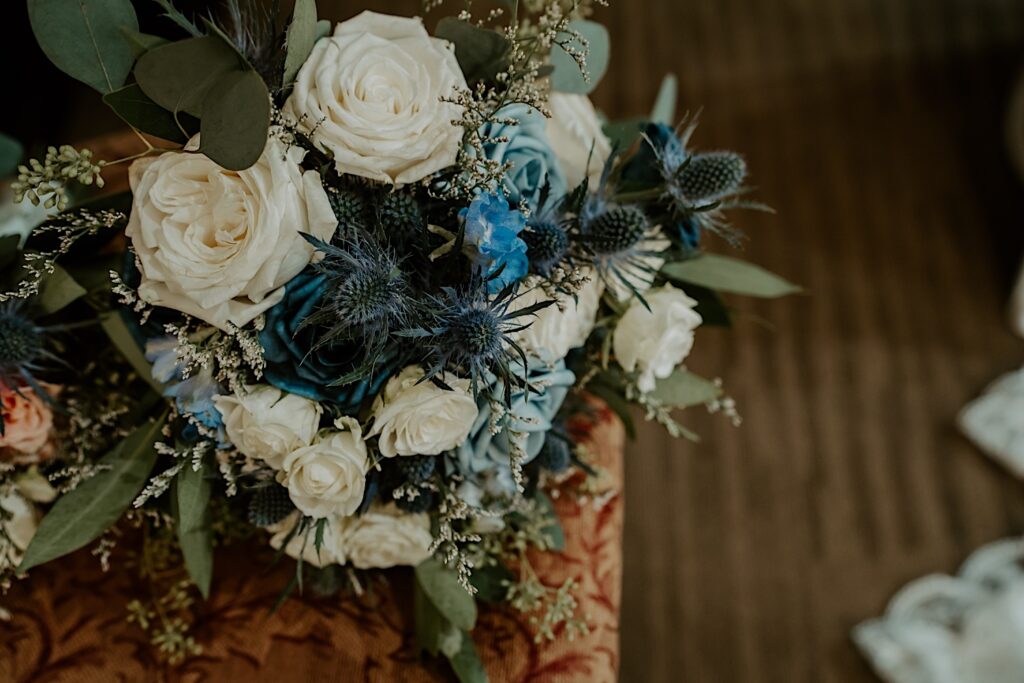 Indianapolis Wedding Photographer capture's brides bridal bouquet with white roses, green filler and blue flowers. 