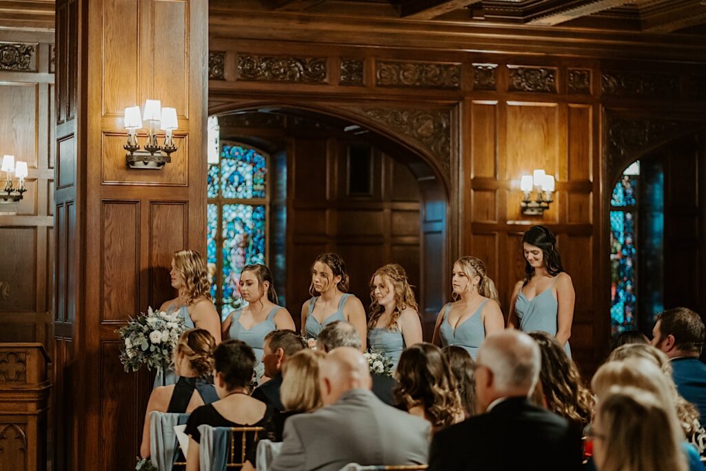 Bridesmaids watch while standing behind the brides during their wedding ceremony inside the Scottish Rite Cathedral in Indianapolis. 