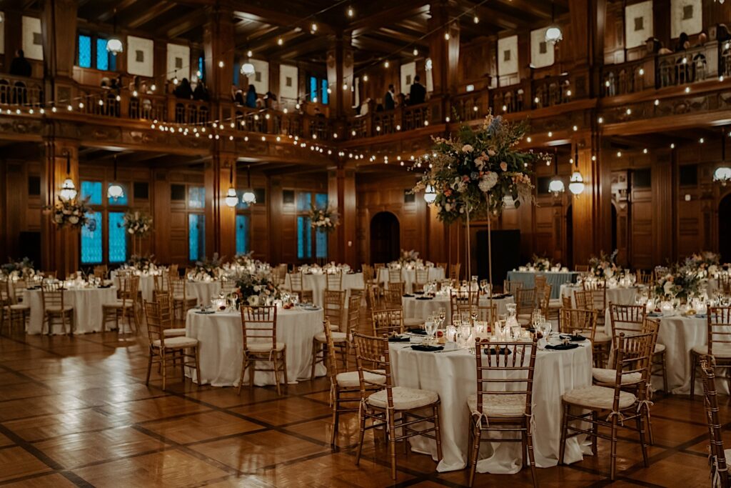 Indianapolis Wedding Photographer captures the 1920's style reception room with table with Ivory tablecloths and gold chairs. 