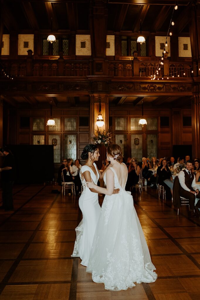 Brides do their first dance with a live band playing behind them in the 1920's style wedding reception hall in Indianapolis.