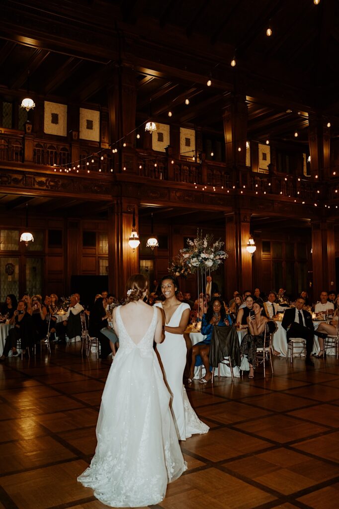 Brides do their first dance with a live band playing behind them in the 1920's style wedding reception hall in Indianapolis.