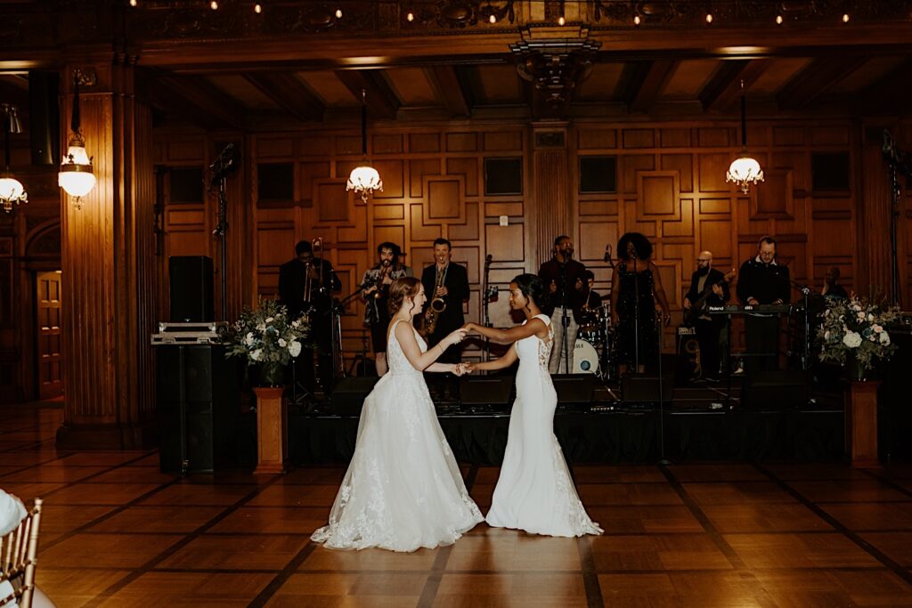 Brides do their first dance with a live band playing behind them in the 1920's style wedding reception hall in Indianapolis.