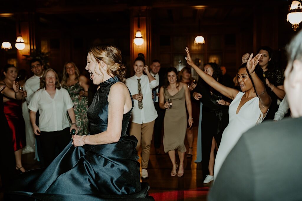 Bride follows guest during dance on reception floor at Scottish Rite Cathedral in Indianapolis. 