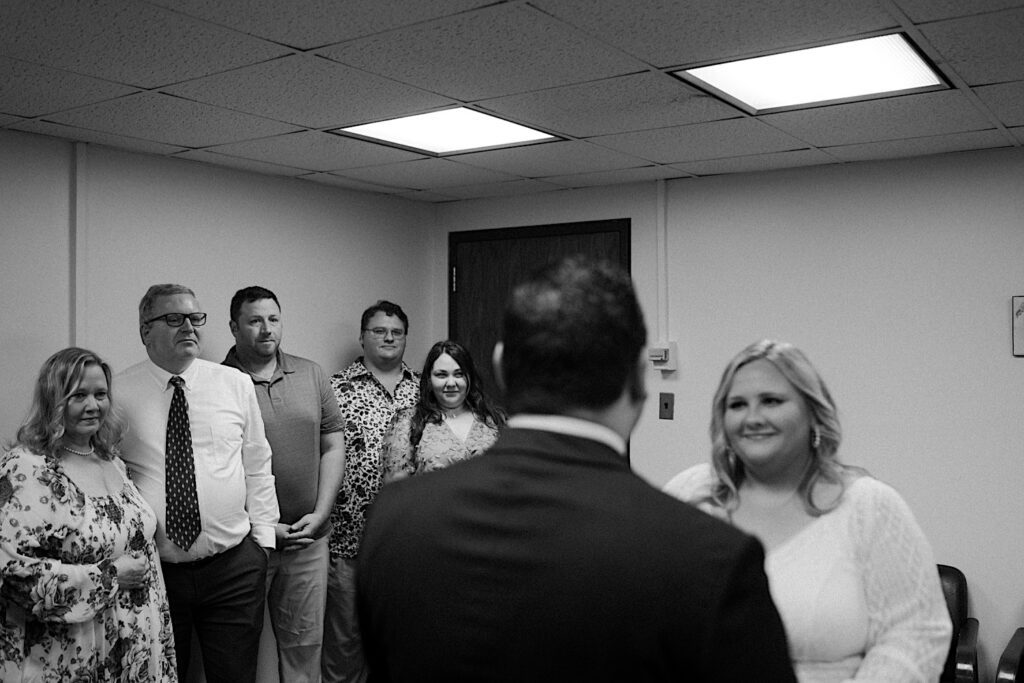 Bride smiles at the Groom during elopement ceremony at Chicago City Hall in a stunning black and white portrait by Midwest Elopement photographer. 