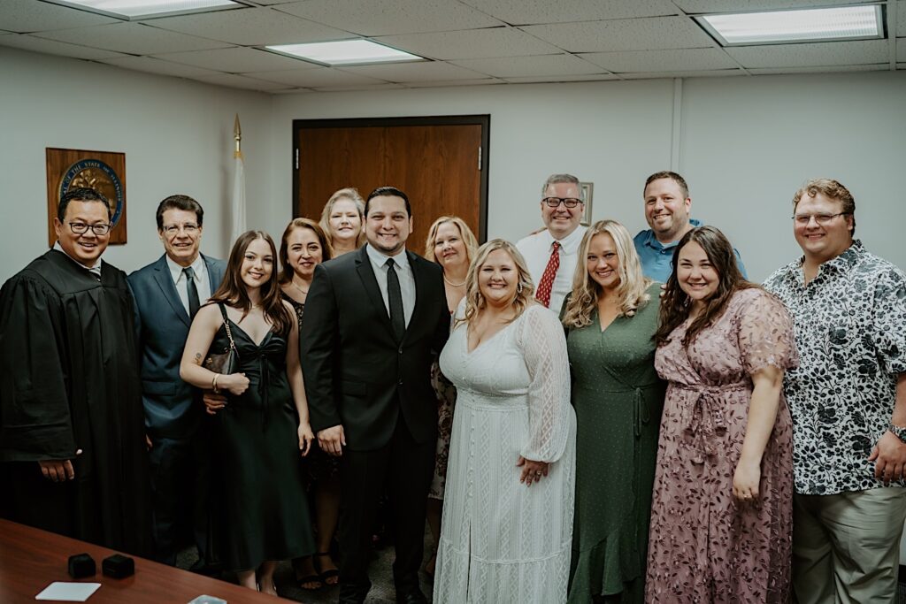 Bride and Groom pose with their families after intimate wedding ceremony at Chicago's City Hall. 