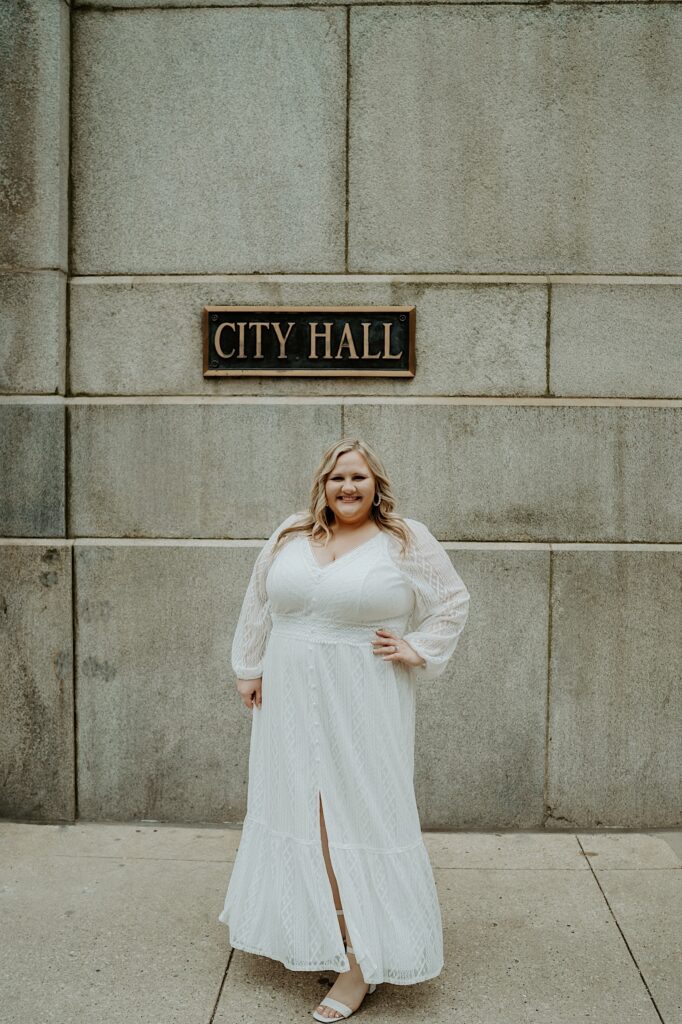 Bride poses with her hands on her hips outside Chicago City Hall. 