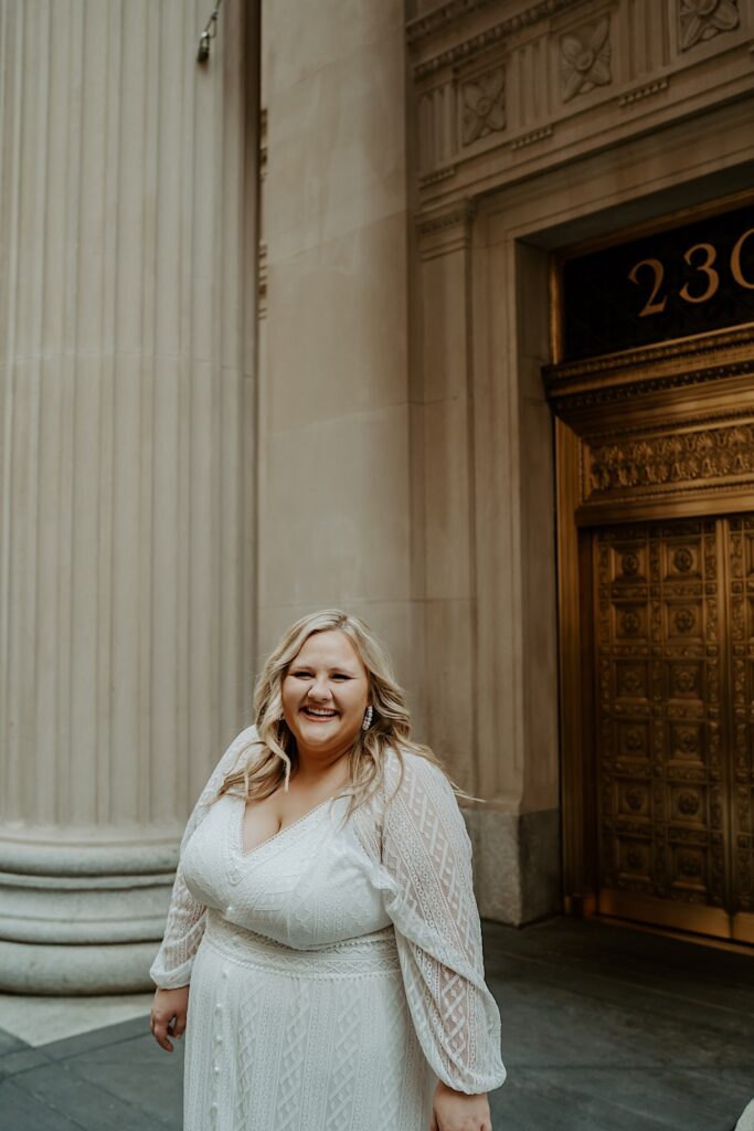 Bride smiles at the camera while wearing a long lace dress during bridal elopement portraits in downtown Chicago. 