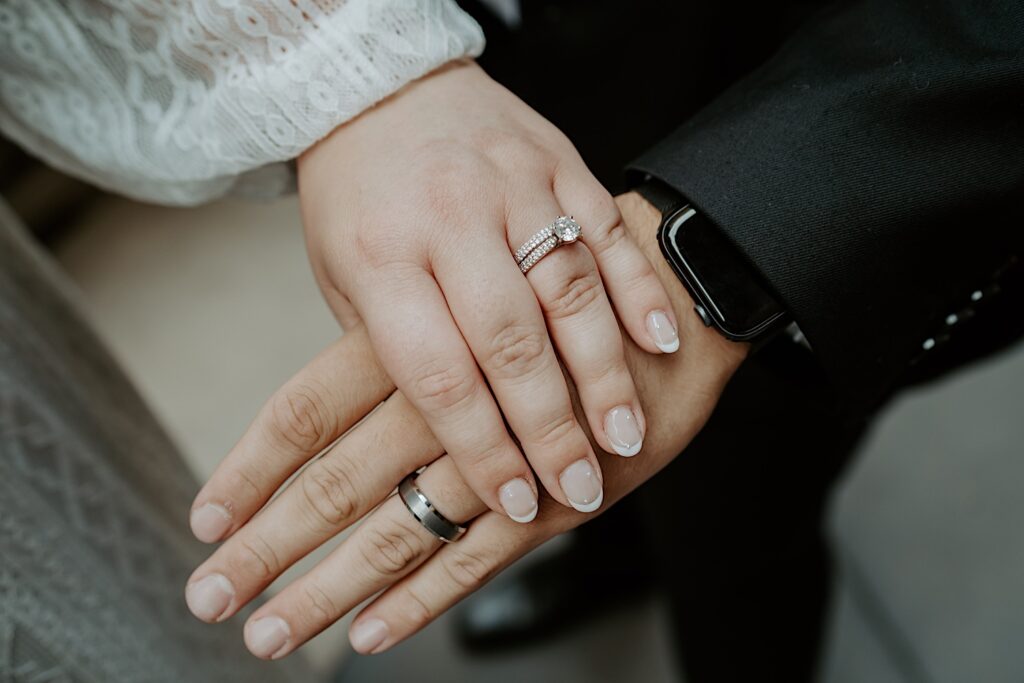 Midwest Elopement photographer captures Bride and groom's hands on-top of one another showing off their wedding rings. 