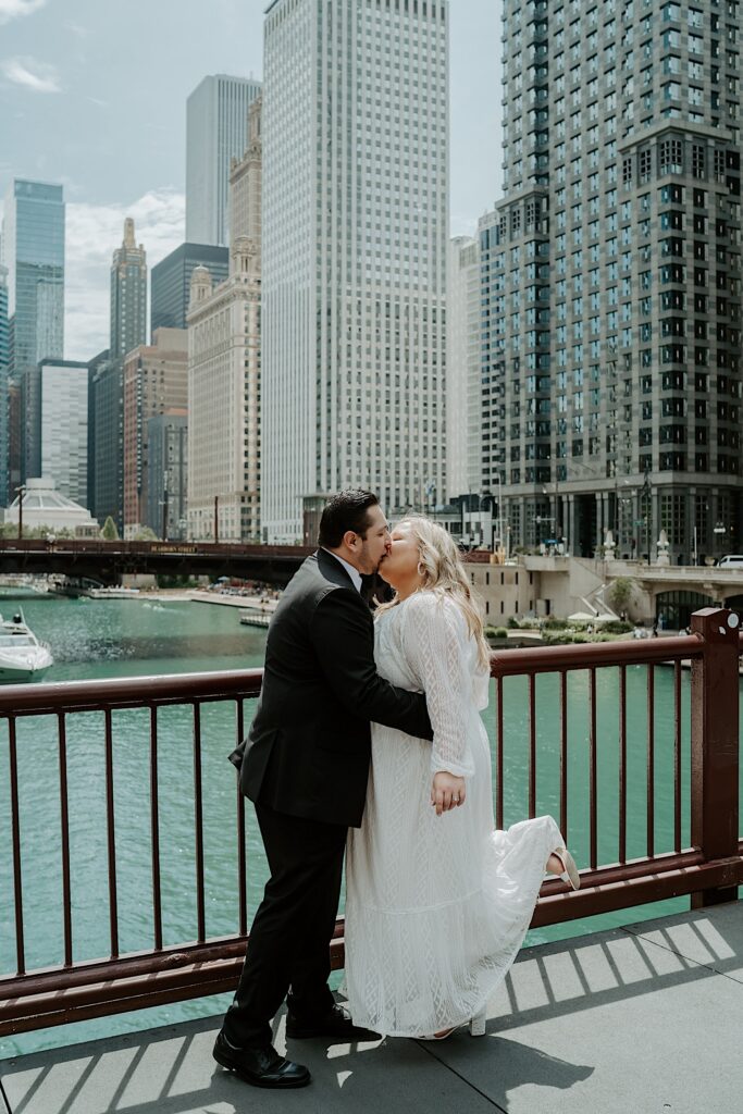 Bride and Groom kiss on Chicago bridge with Chicago river and Wacker street in the background for romantic city elopement portraits. 