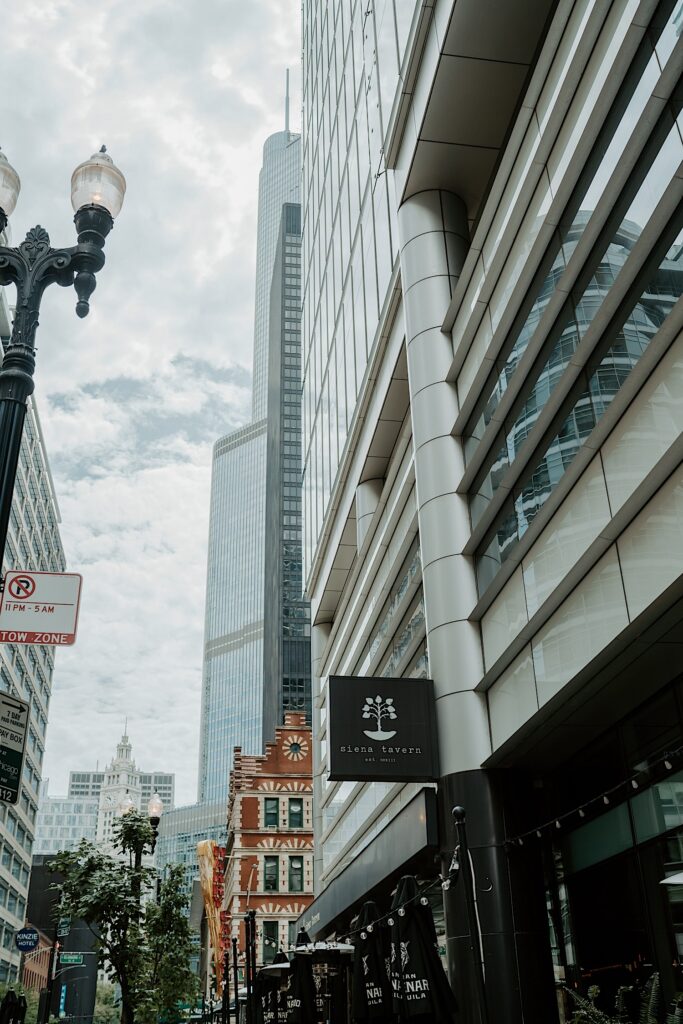 Midwest Elopement Photographer captures the front of Siena Tavern sign with buildings in the background. 