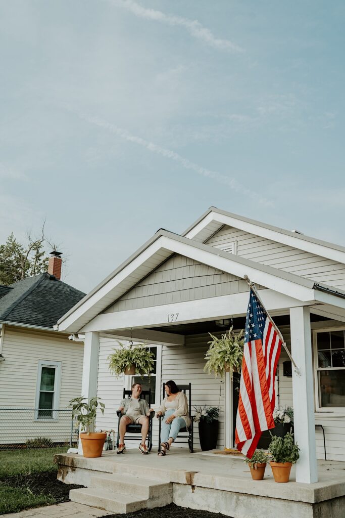 Couple sits on the porch of their home during intimate portraits in Lafayette Indiana.