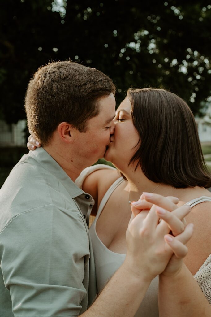 Couple kisses as they hold hands while walking down their street in Lafayette, Indiana. 