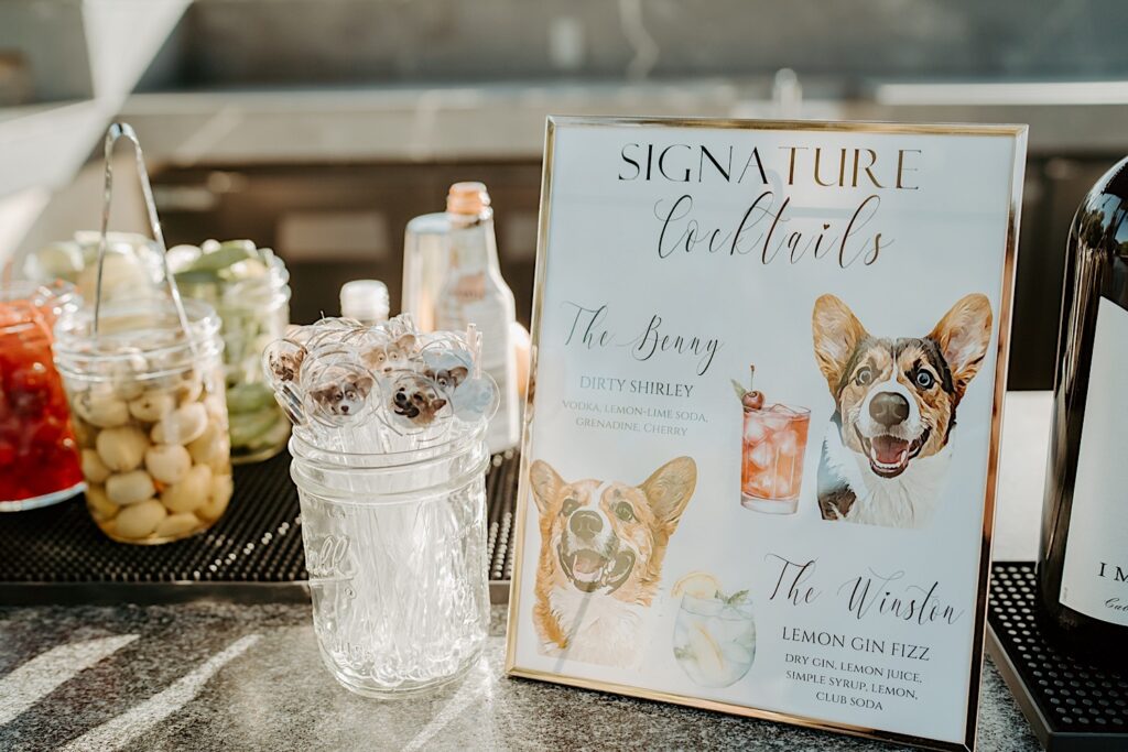 A custom drink menu and drink stirrers with illustrations of their corgis faces on them. 