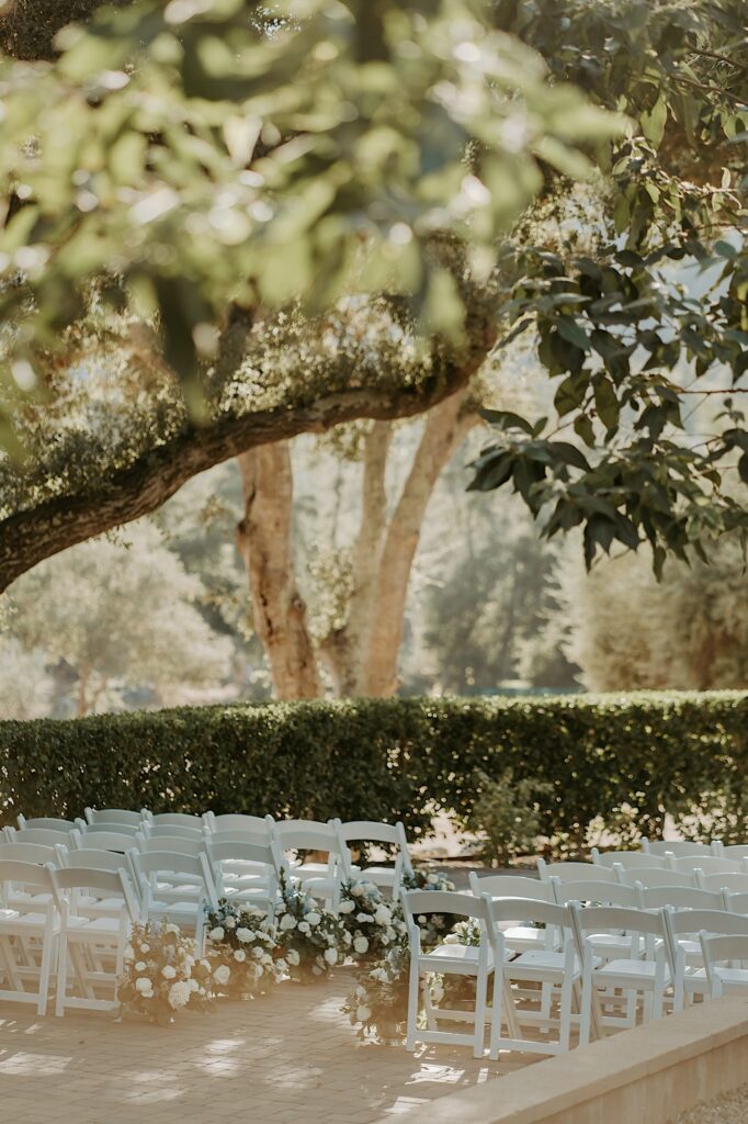 Outdoor wedding ceremony in California with white rose end caps. 