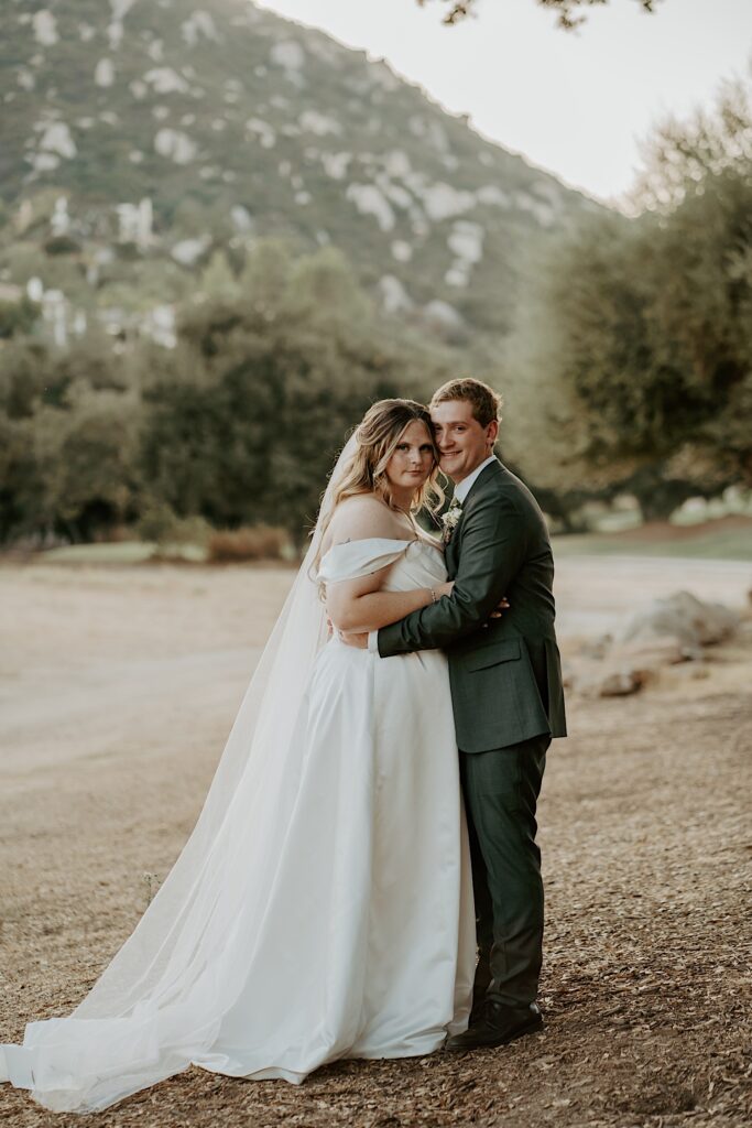 A bride and groom walk together in the California desert during their wedding at Mt Woodson Castle