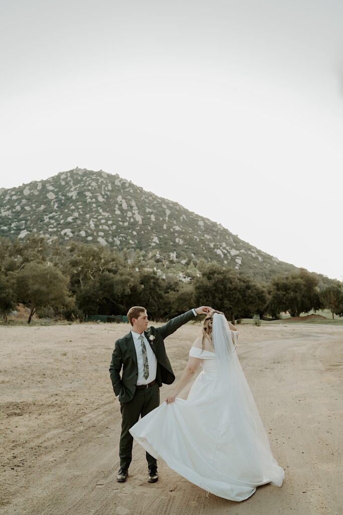 A bride and groom dance together in the California desert during their wedding at Mt Woodson Castle